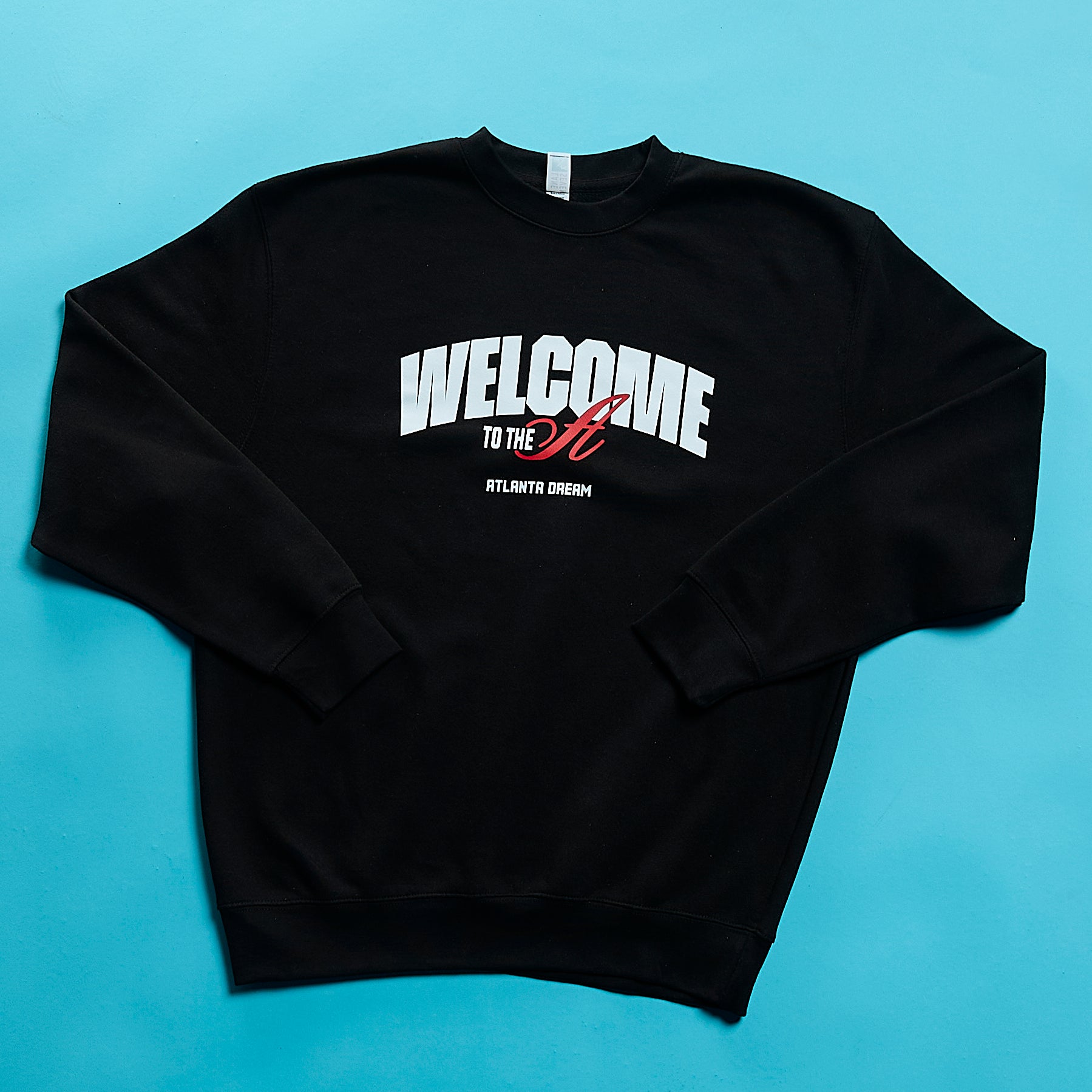 Black sweatshirt with 'Welcome to the Dream' text on a blue background