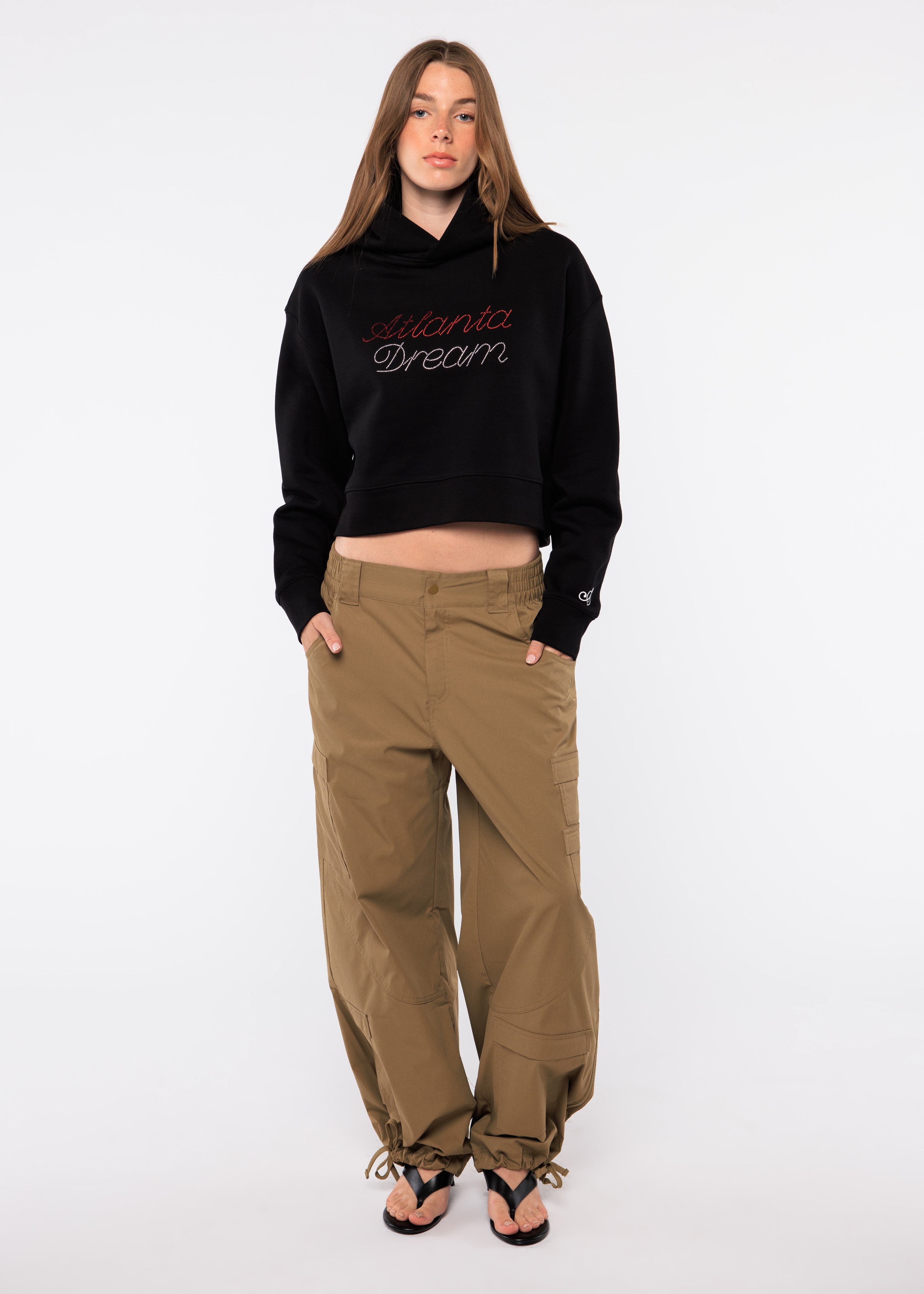 Person wearing a black hoodie with text and beige pants 