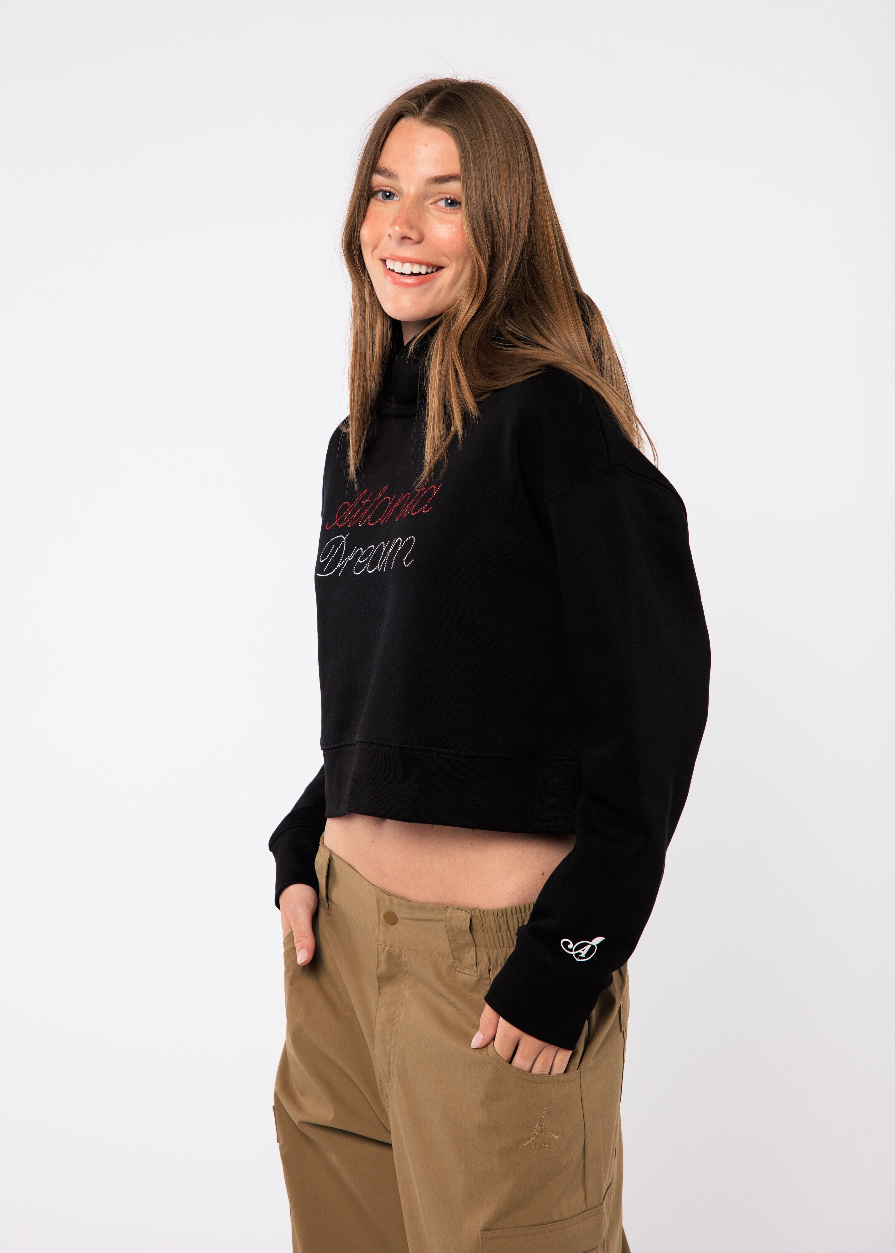 Woman wearing a black hoodie with text and beige pants