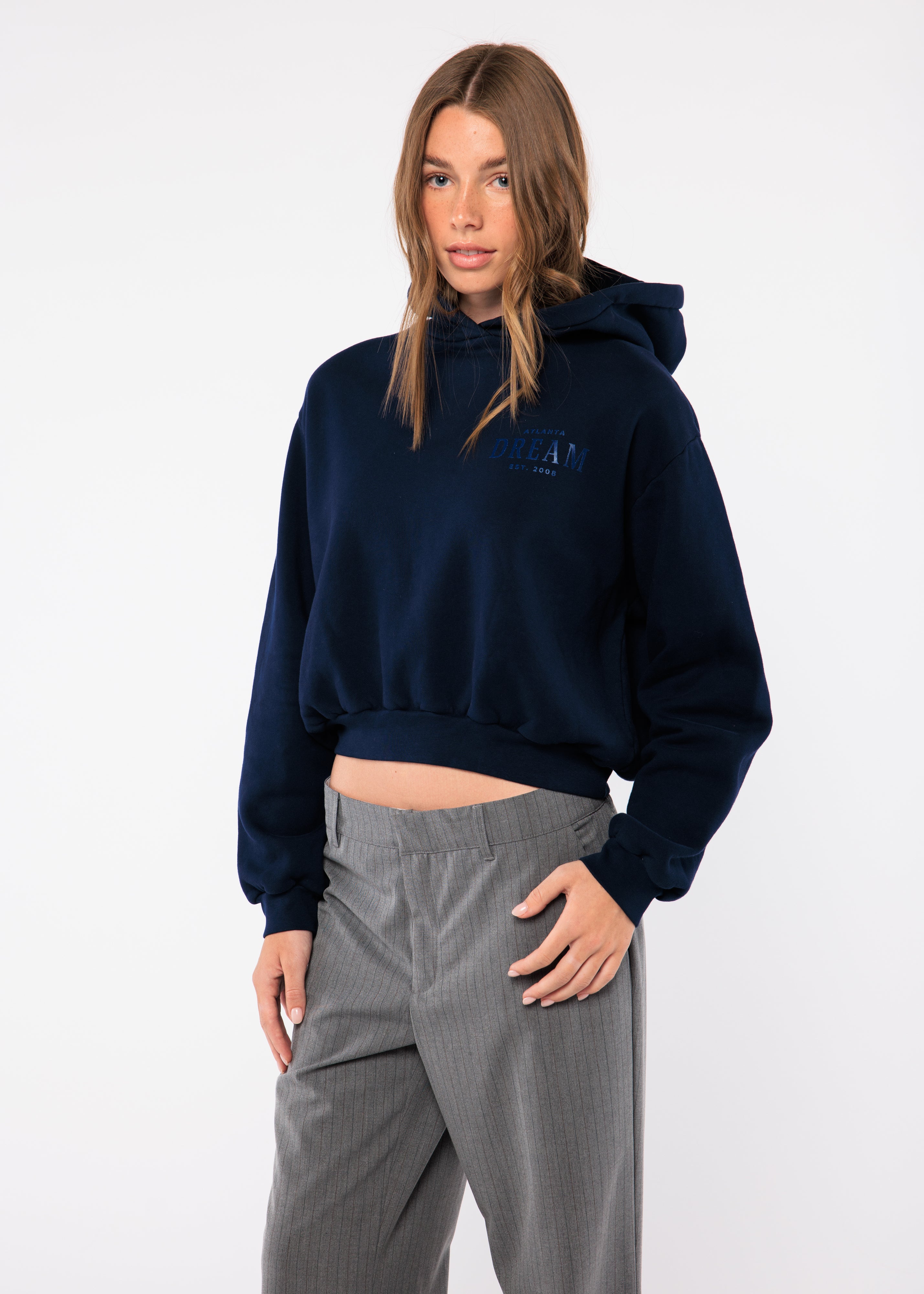 Person wearing a navy blue hoodie and gray pants