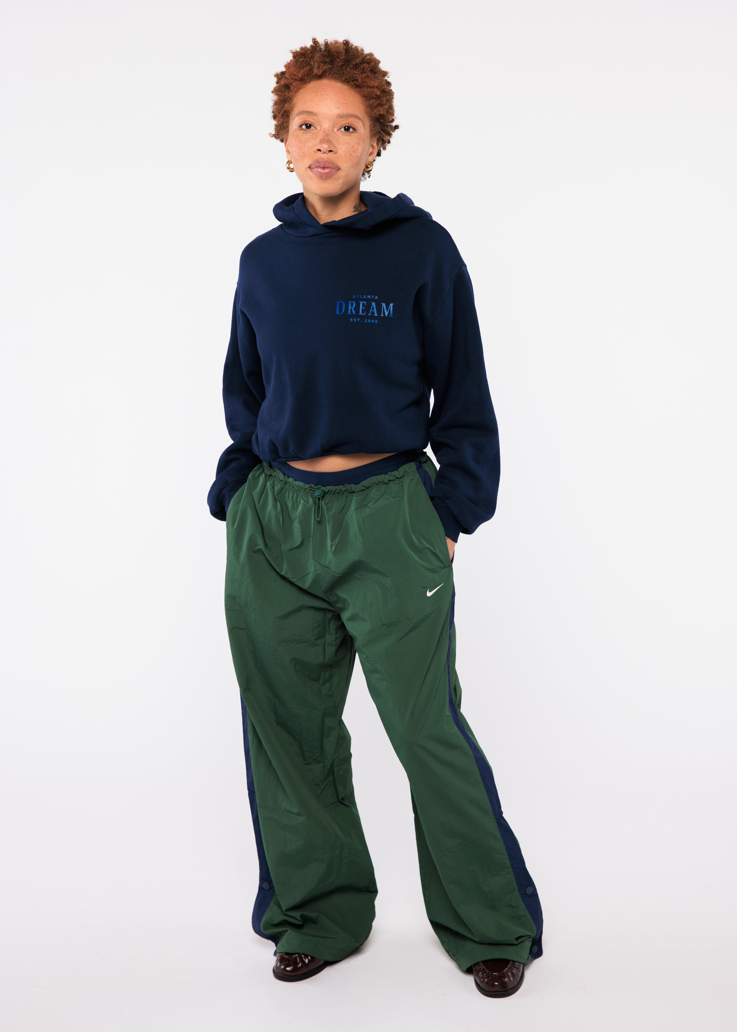 Person wearing a navy hoodie and green pants