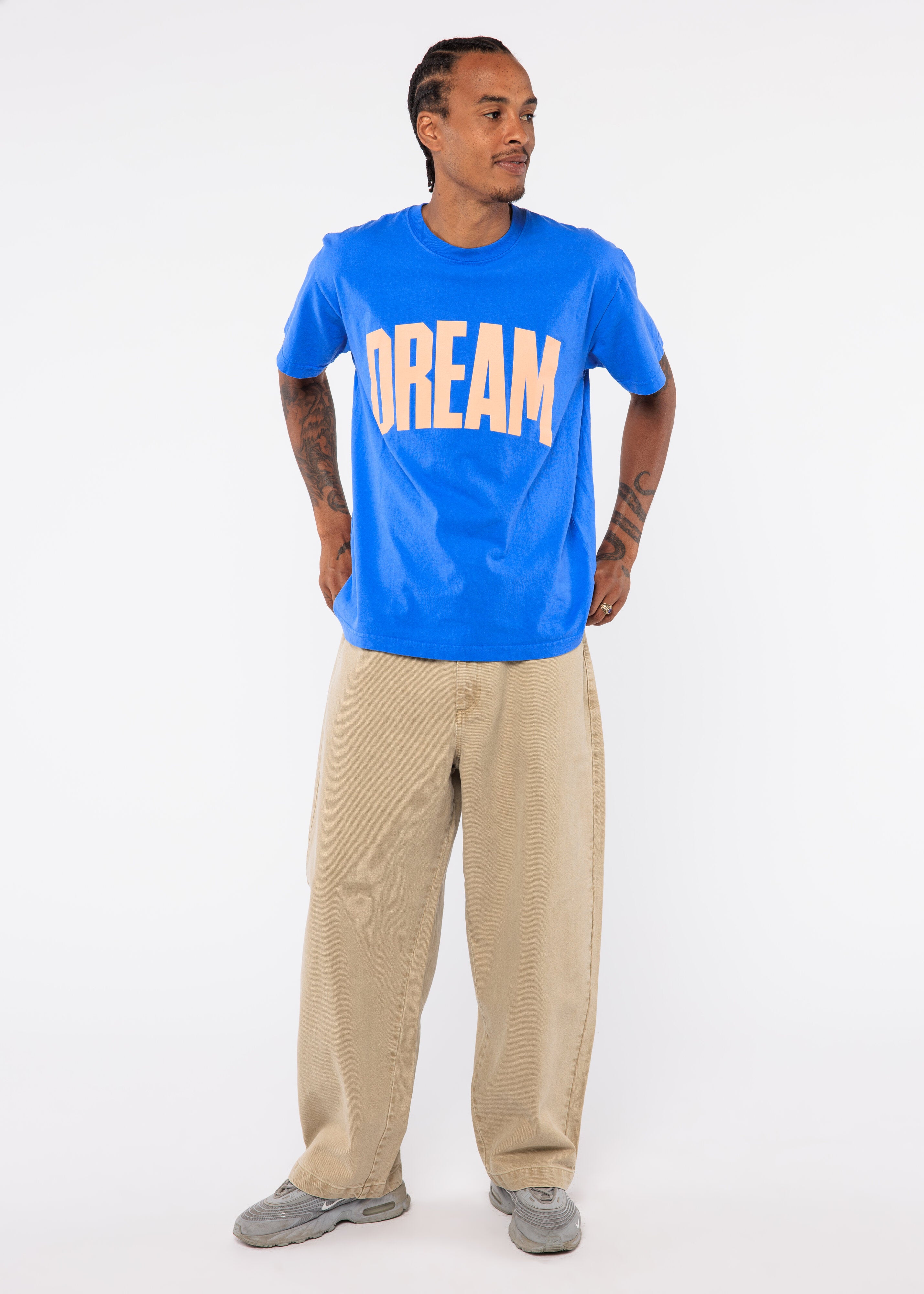 Person wearing a blue t-shirt with 'DREAM' printed on it