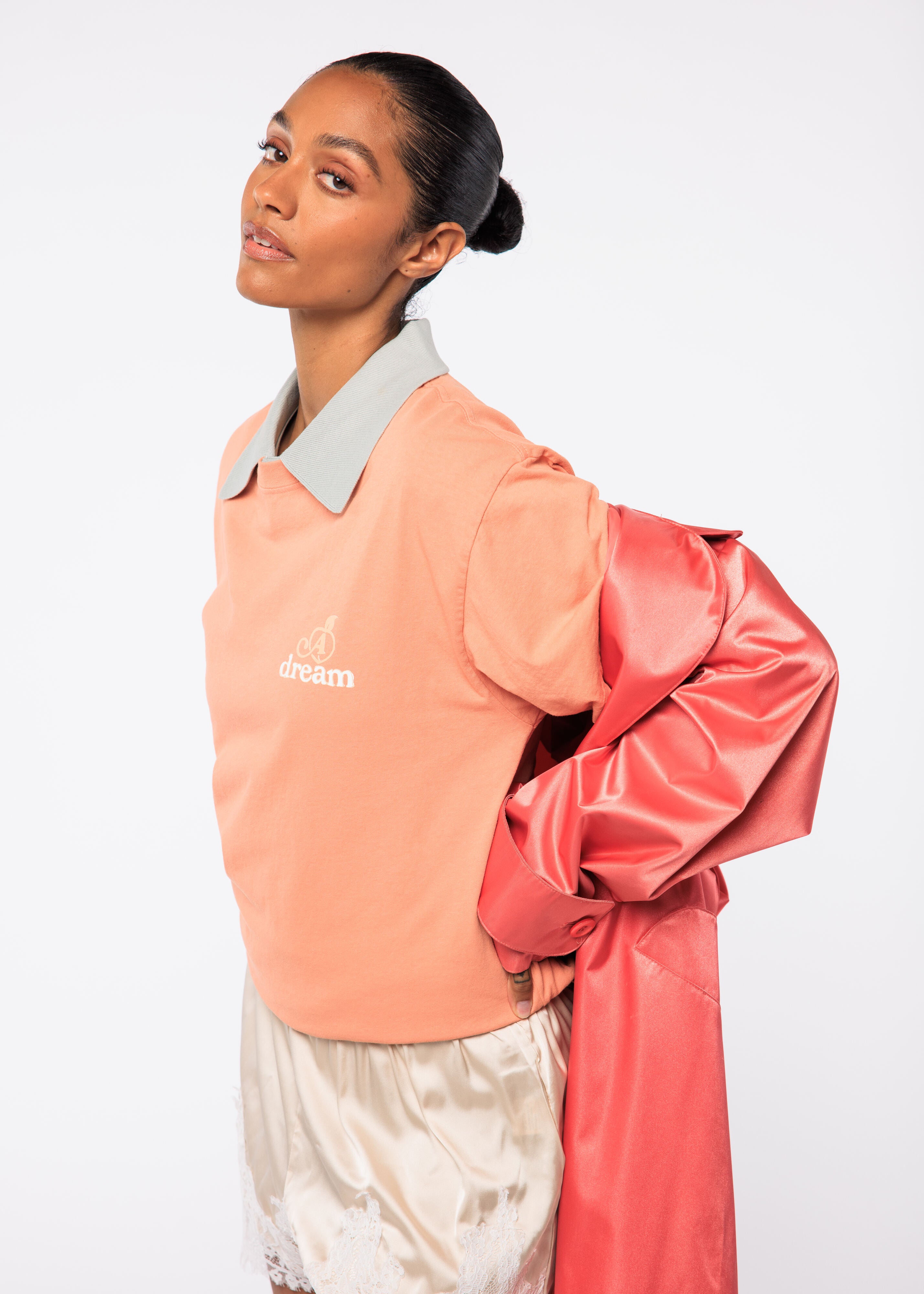 Woman wearing a peach-colored jacket with a brand logo