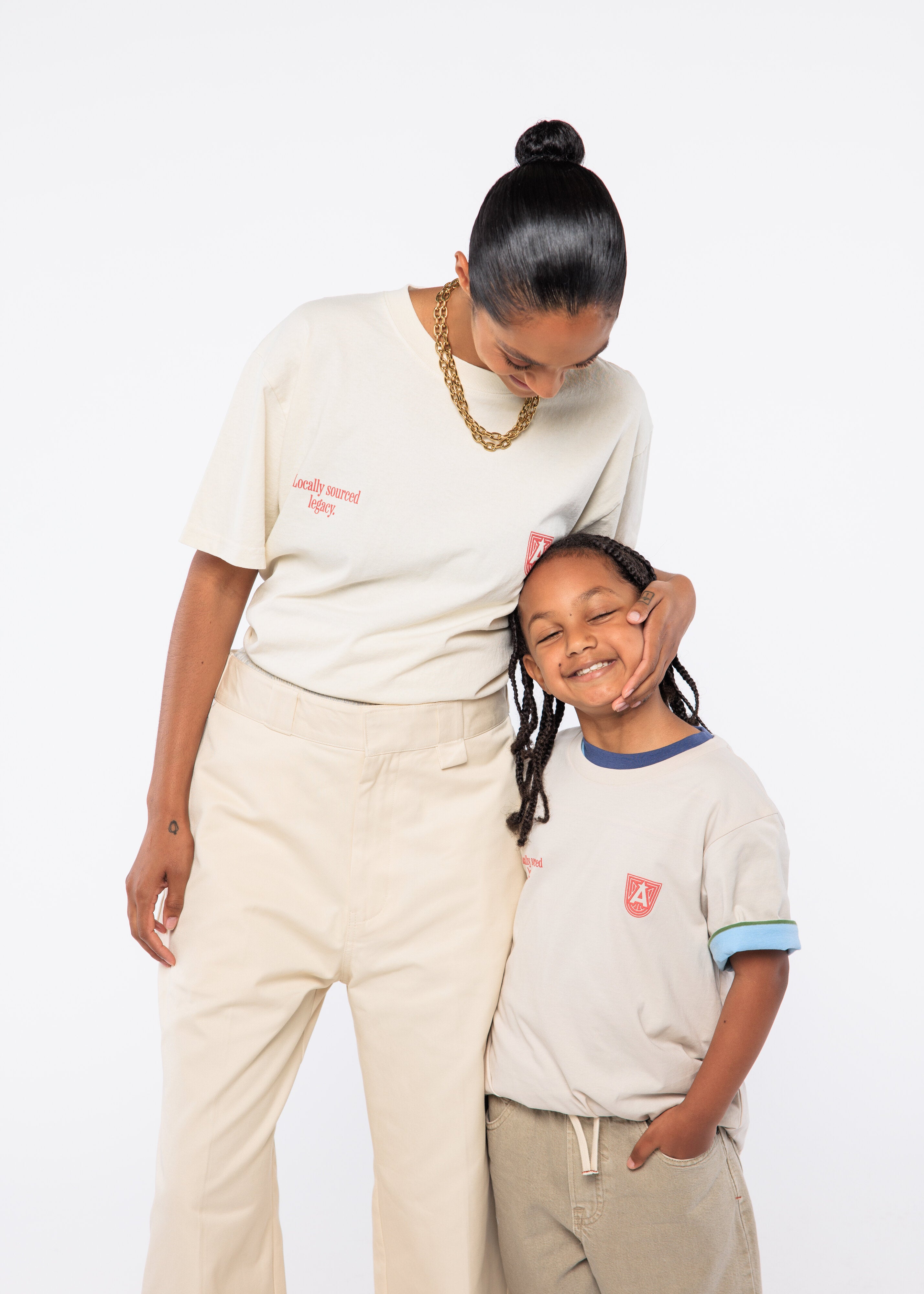 Woman and child standing close together wearing matching outfits with visible brand logos.