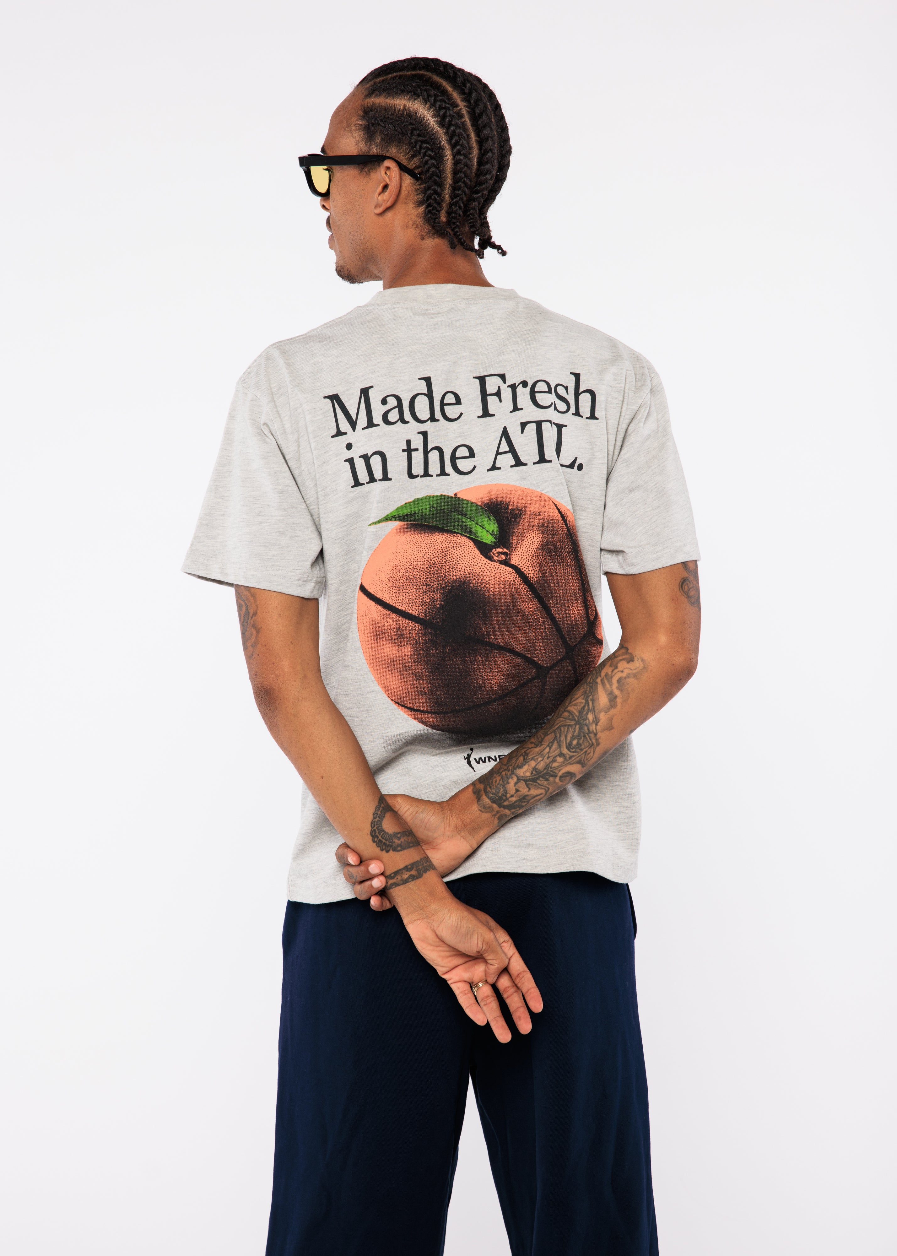 Wearing a t-shirt with a graphic of a peach on a basketball and text 'Made Fresh in the ATL'.