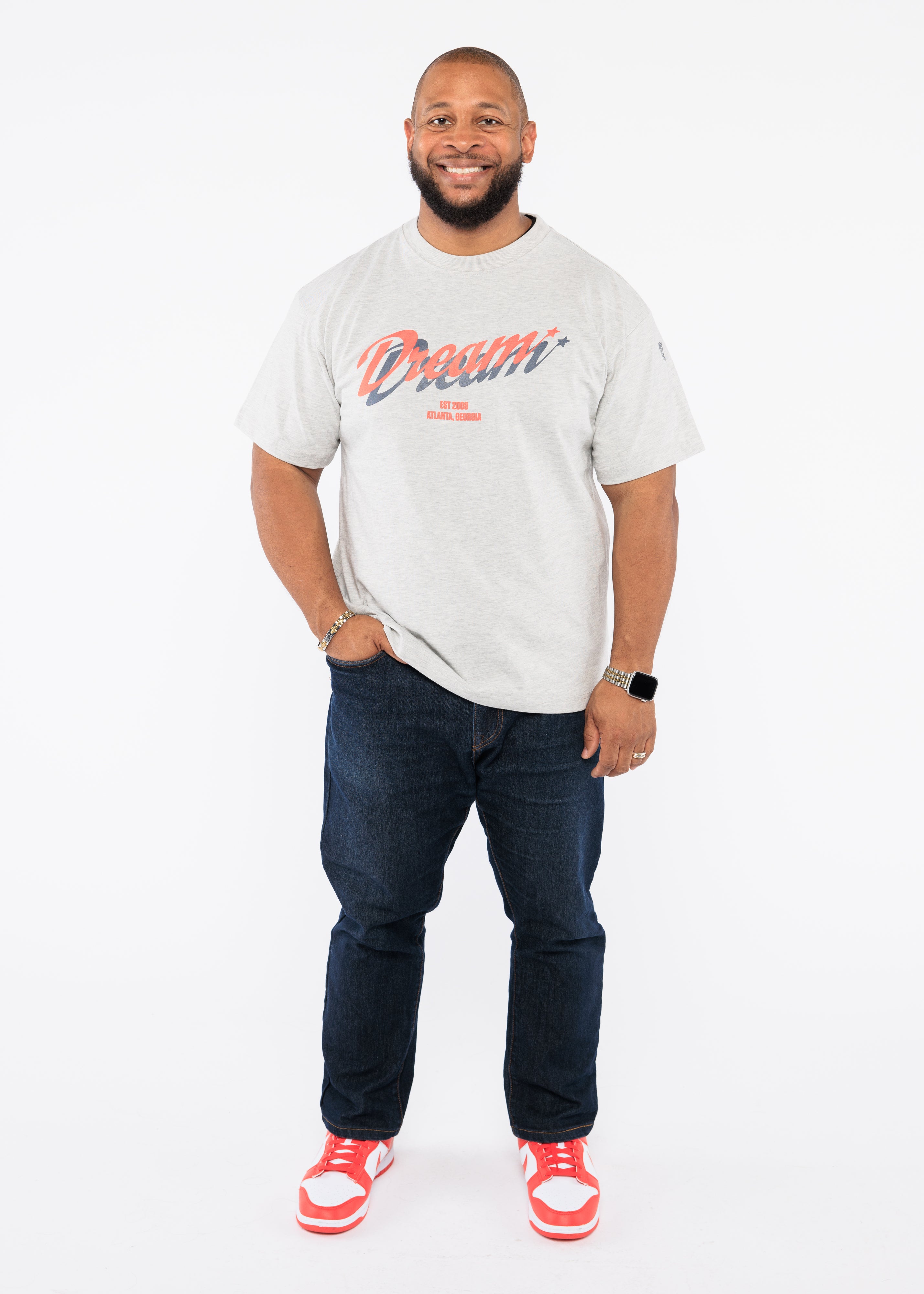 Man wearing a white t-shirt with text and dark jeans