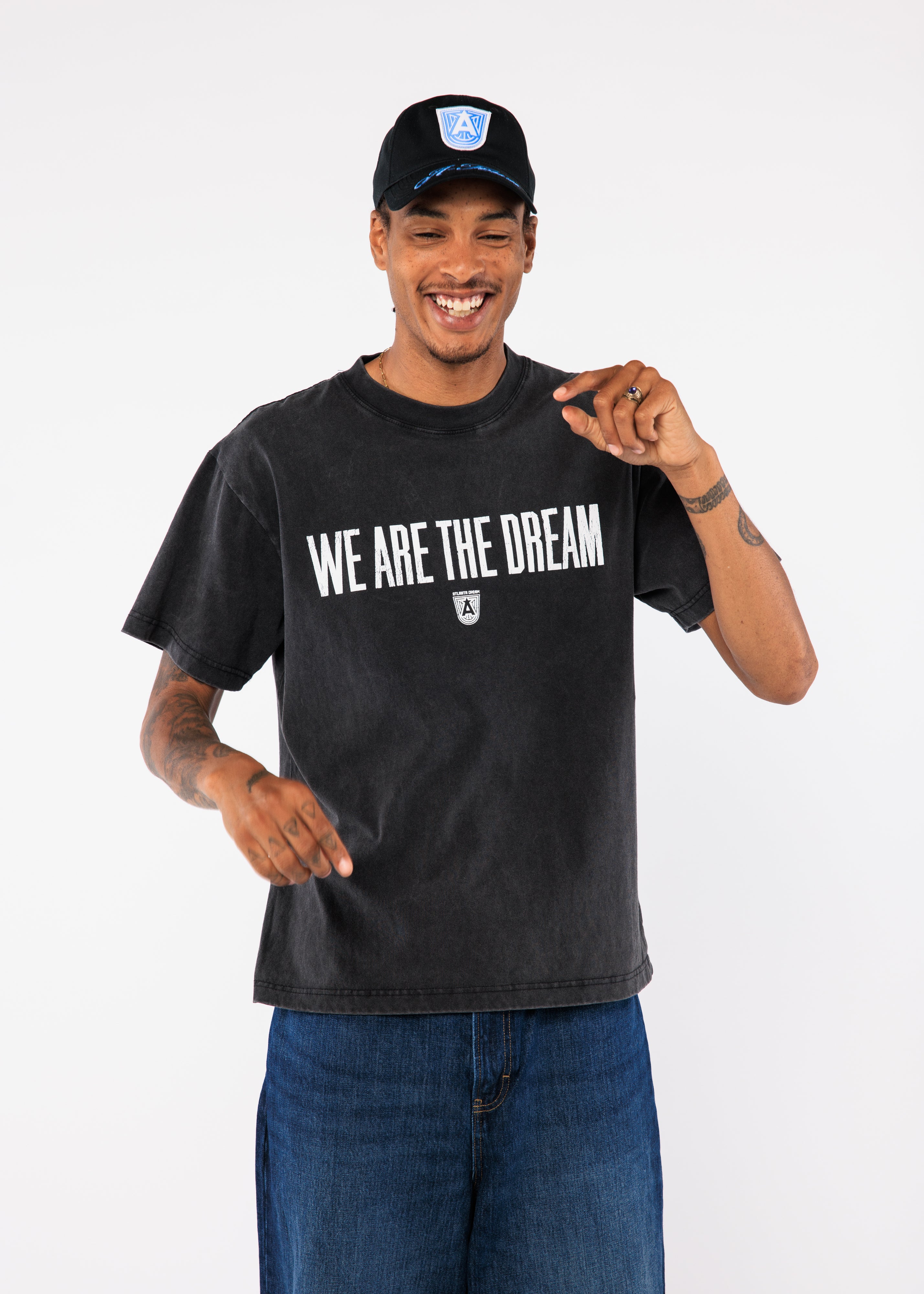 A black t-shirt with 'We Are The Dream' text and a cap