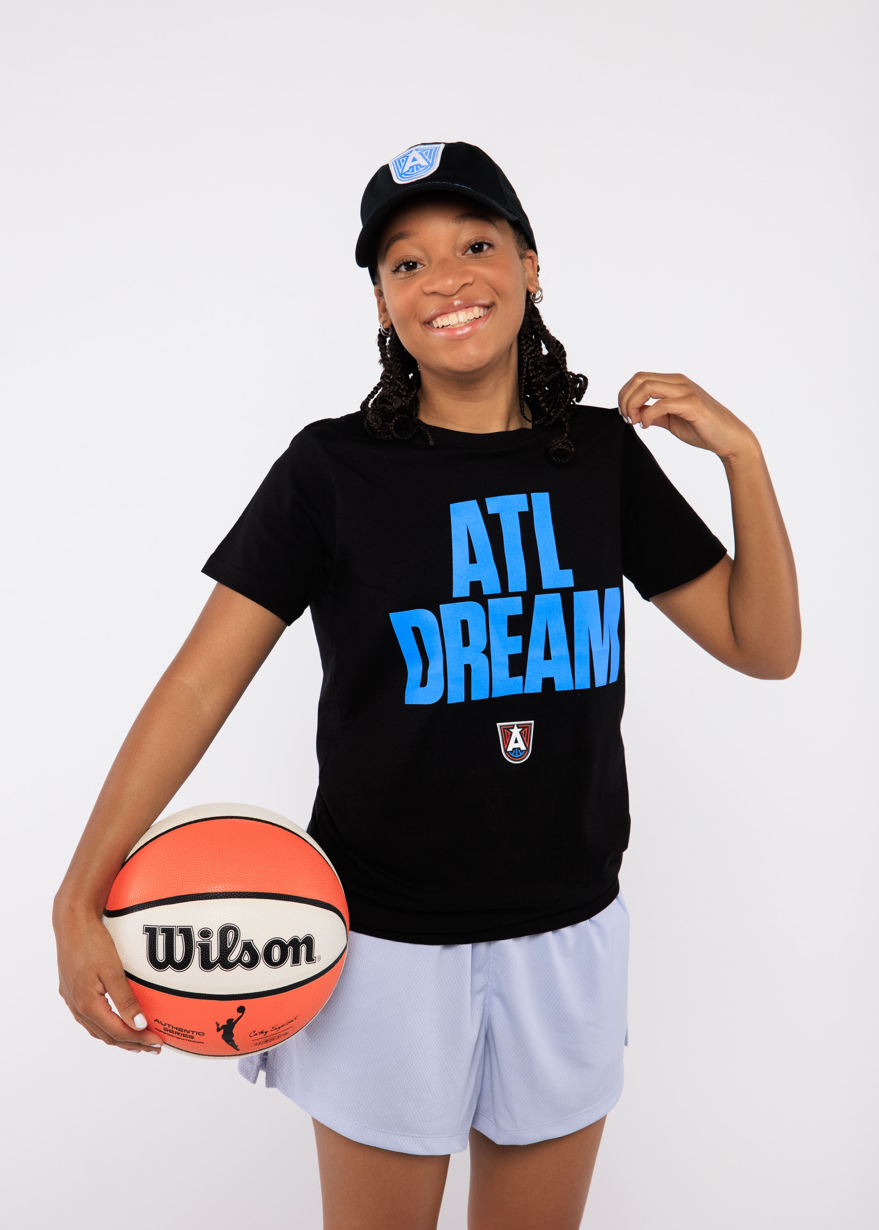 Person wearing a black 'ATL DREAM' t-shirt holding a Wilson basketball