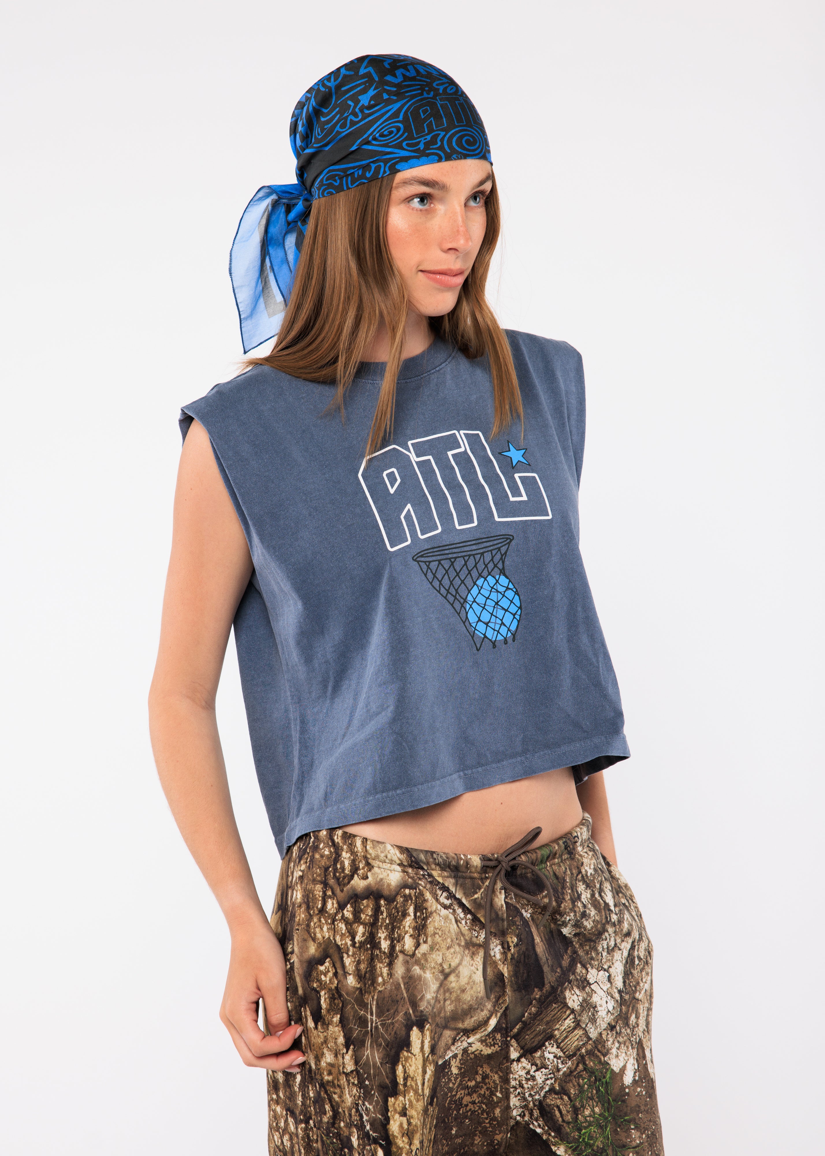 Wearing a sleeveless blue shirt with a logo and camouflage pants