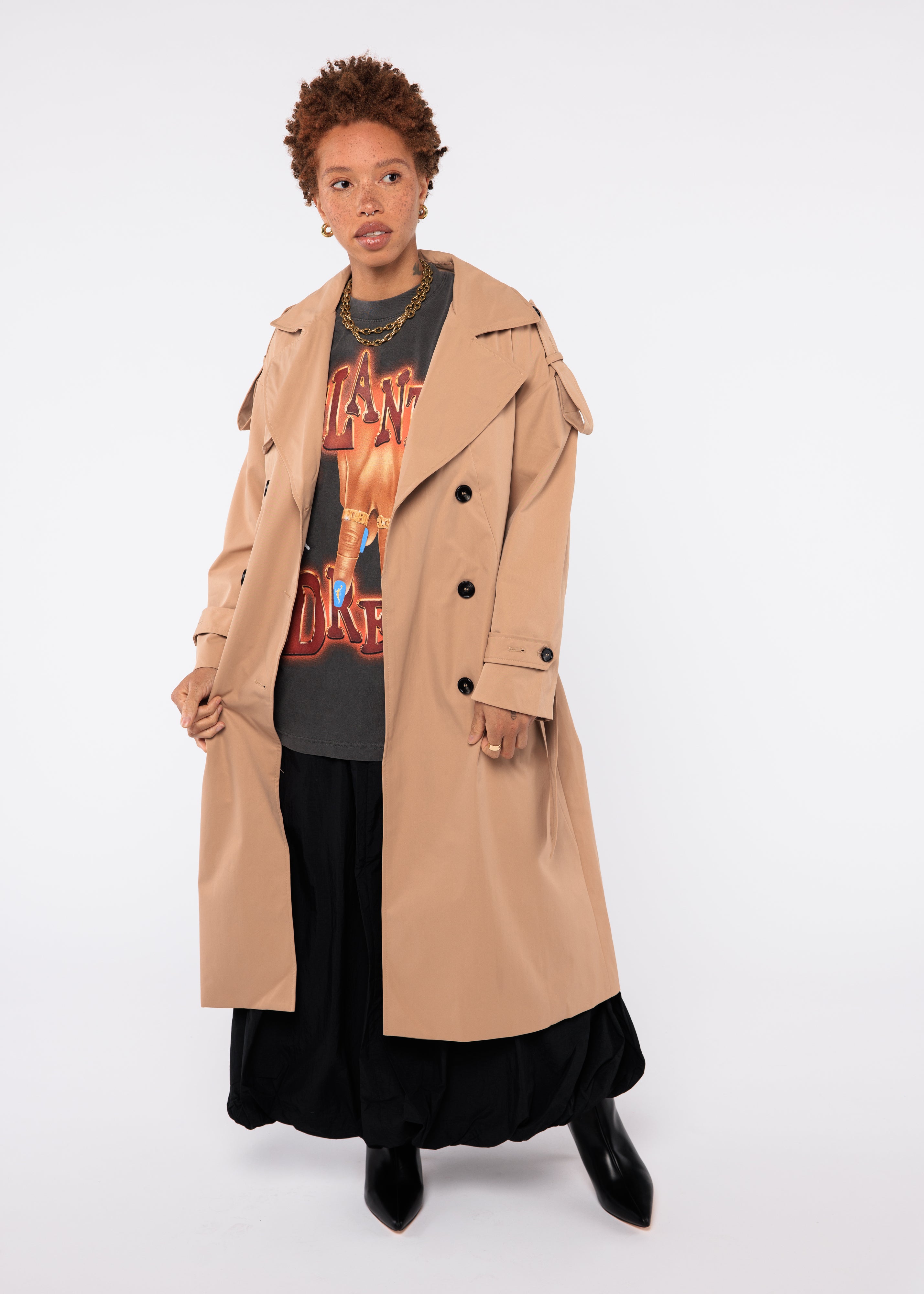 Wearing a beige trench coat over a graphic t-shirt