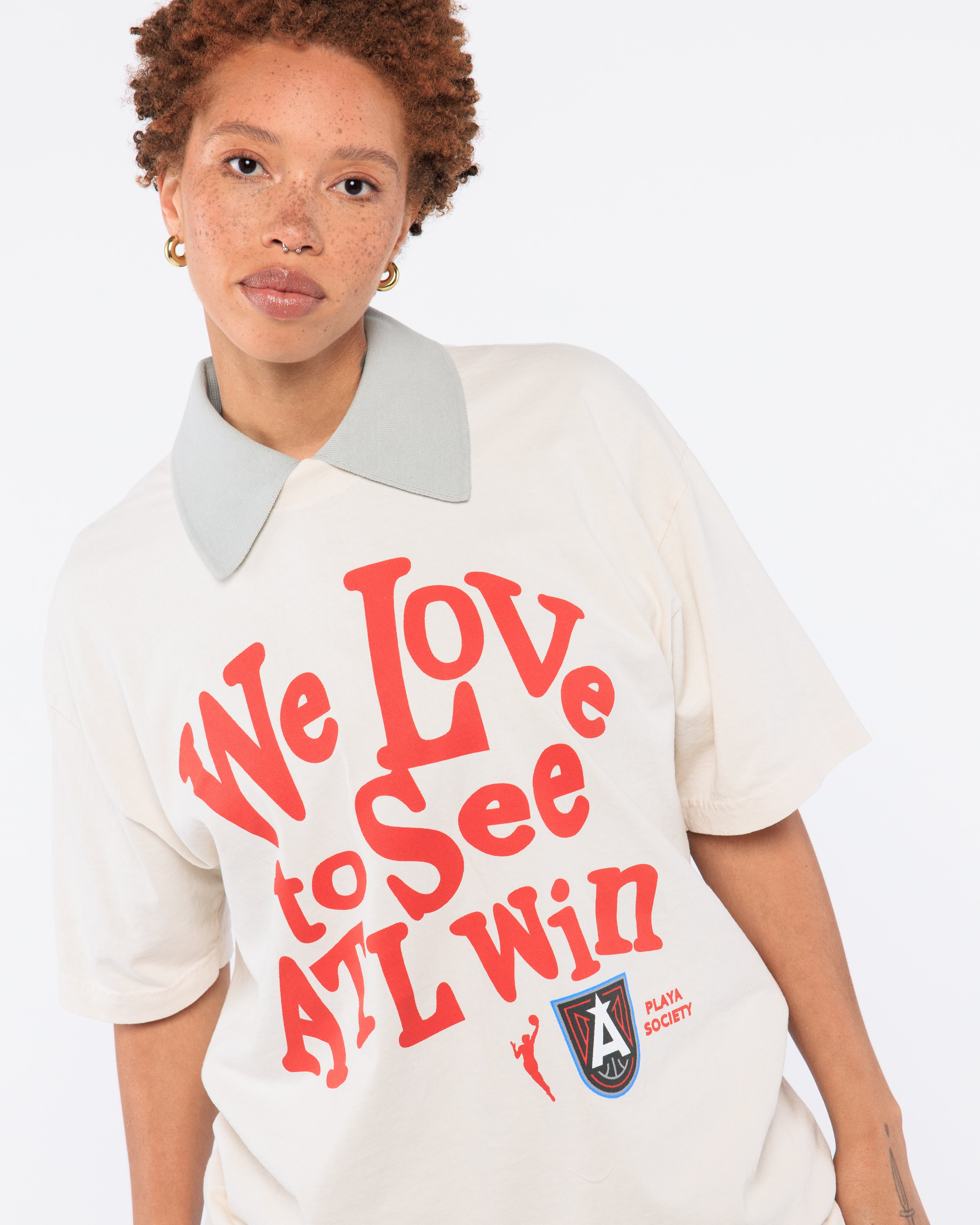 Wearing a white shirt with red text and a logo